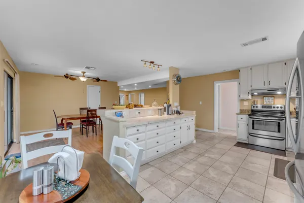 a kitchen with stainless steel appliances kitchen island granite countertop a table and chairs in it
