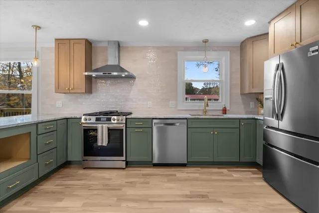 a kitchen with stainless steel appliances granite countertop a stove a sink and a refrigerator