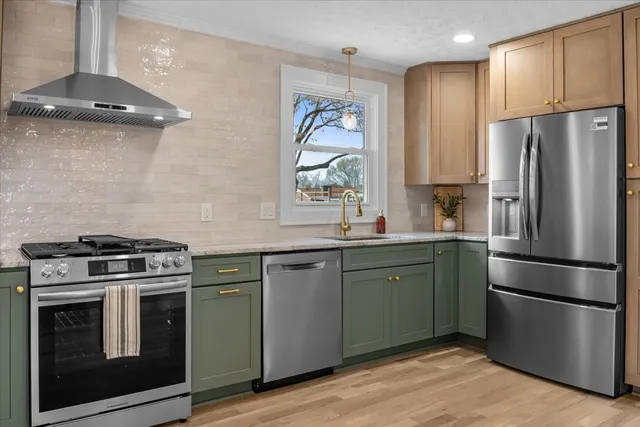 a kitchen with stainless steel appliances granite countertop a stove a refrigerator and a microwave