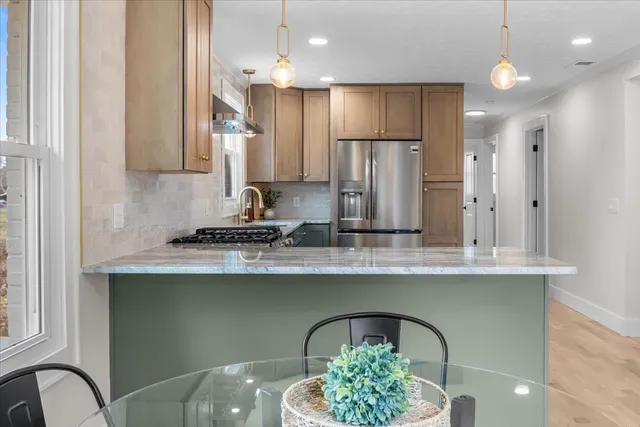 a kitchen with kitchen island stainless steel appliances a sink and a counter space
