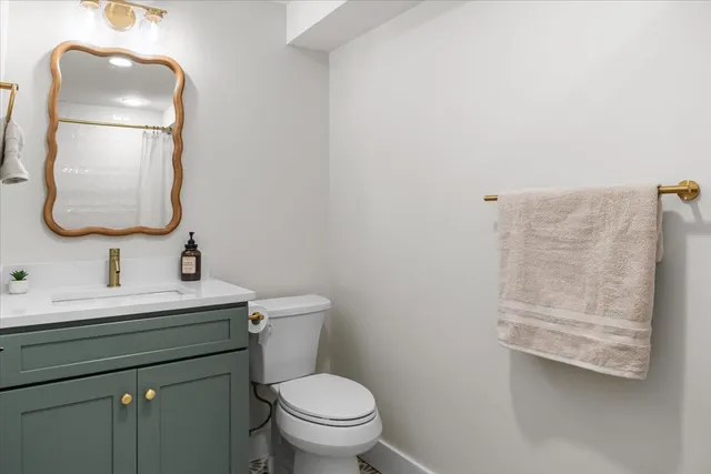 a bathroom with a toilet sink and mirror