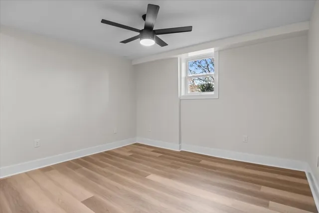 a view of a big room with wooden floor and a ceiling fan