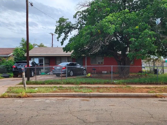 a front view of a house with a garden and trees