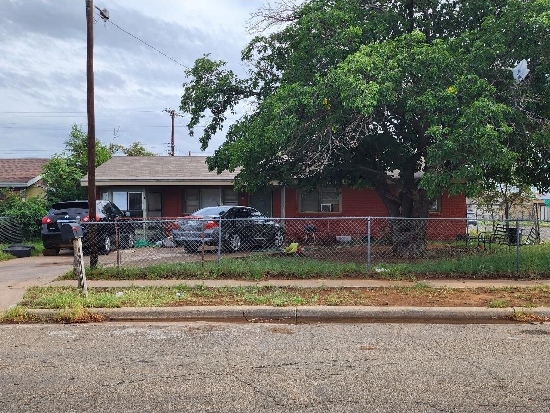 a front view of a house with a garden and trees