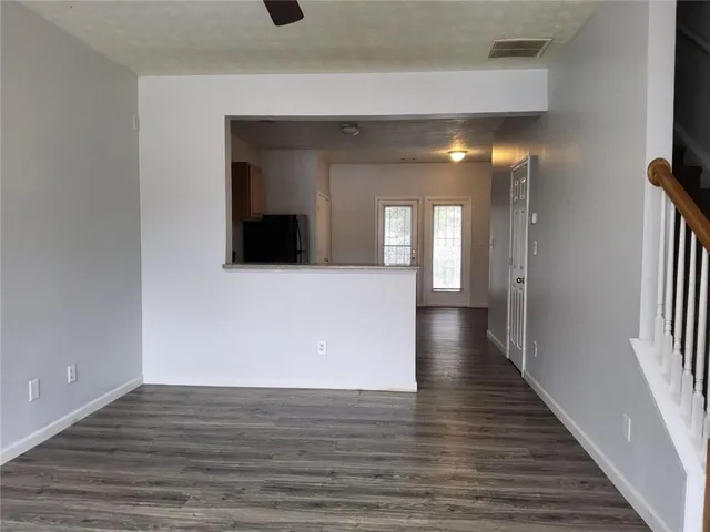 a view of a hallway with wooden floor and staircase