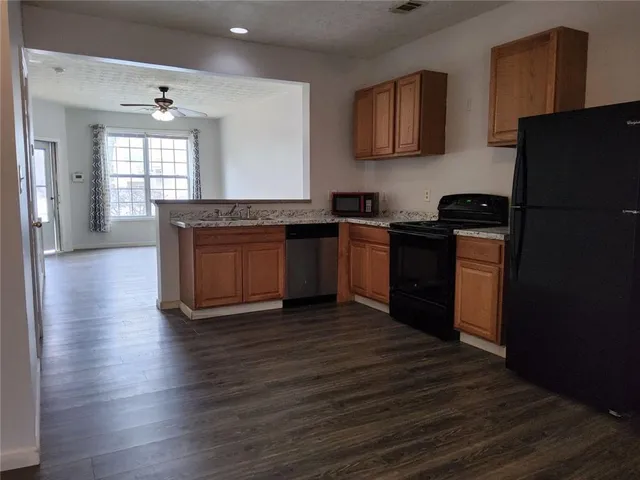 a kitchen with granite countertop stainless steel appliances and wooden cabinets