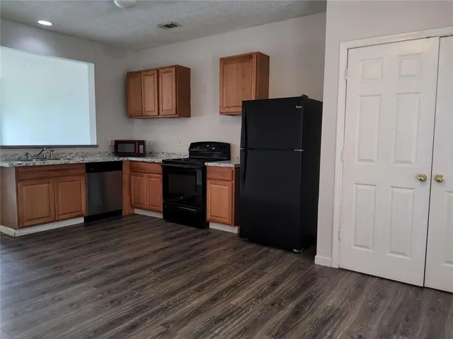a kitchen with a refrigerator and a stove top oven