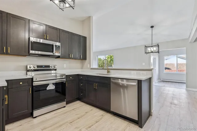 a kitchen with stainless steel appliances granite countertop wooden cabinets a sink and a stove