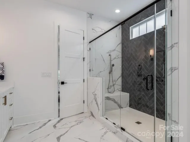 a bathroom with a glass shower door and a sink