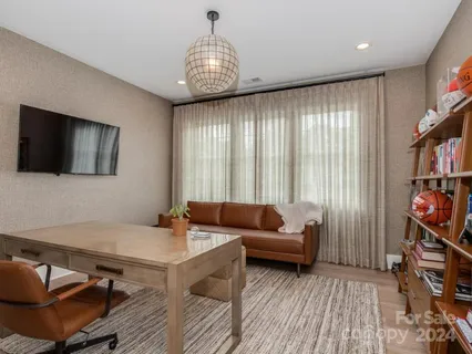 a living room with furniture a flat screen tv and a book shelf