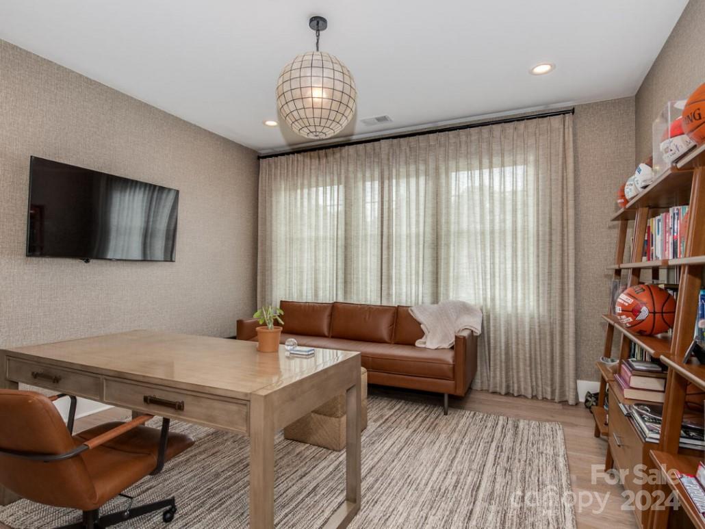 1013 Maxwell Court, Unit 4 Marvin, NC 28173 - Photo 18 of 20 a living room with furniture a flat screen tv and a book shelf
