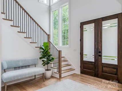 a hallway with stairs and a livingroom with furniture