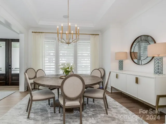 a dining room with furniture a chandelier and wooden floor