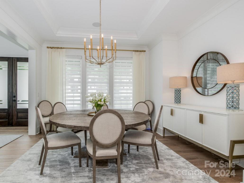 1013 Maxwell Court, Unit 4 Marvin, NC 28173 - Photo 3 of 20 a dining room with furniture a chandelier and wooden floor