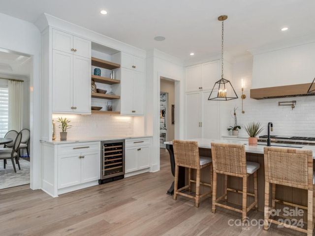 a kitchen with a dining table chairs and cabinets