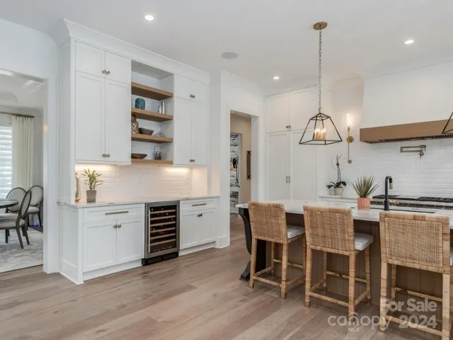 a kitchen with a dining table chairs and cabinets