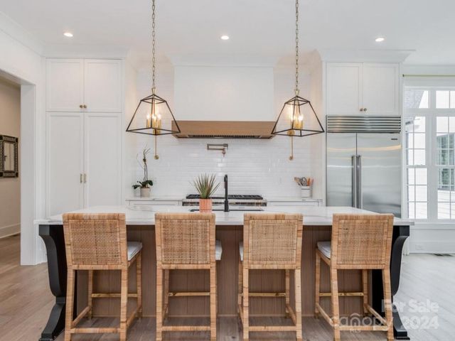 a kitchen with a table a sink cabinets and stainless steel appliances