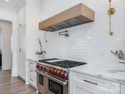 a stove top oven sitting inside of a kitchen