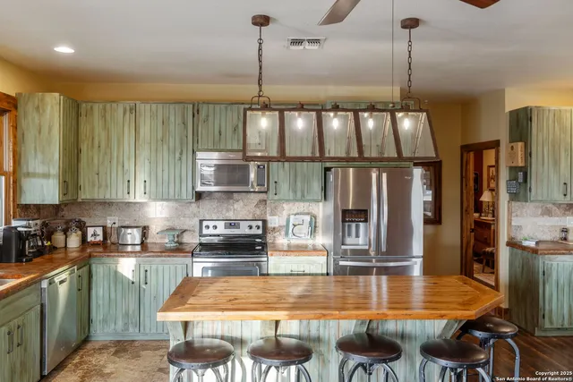 a kitchen with stainless steel appliances kitchen island granite countertop a stove a sink and a granite counter tops