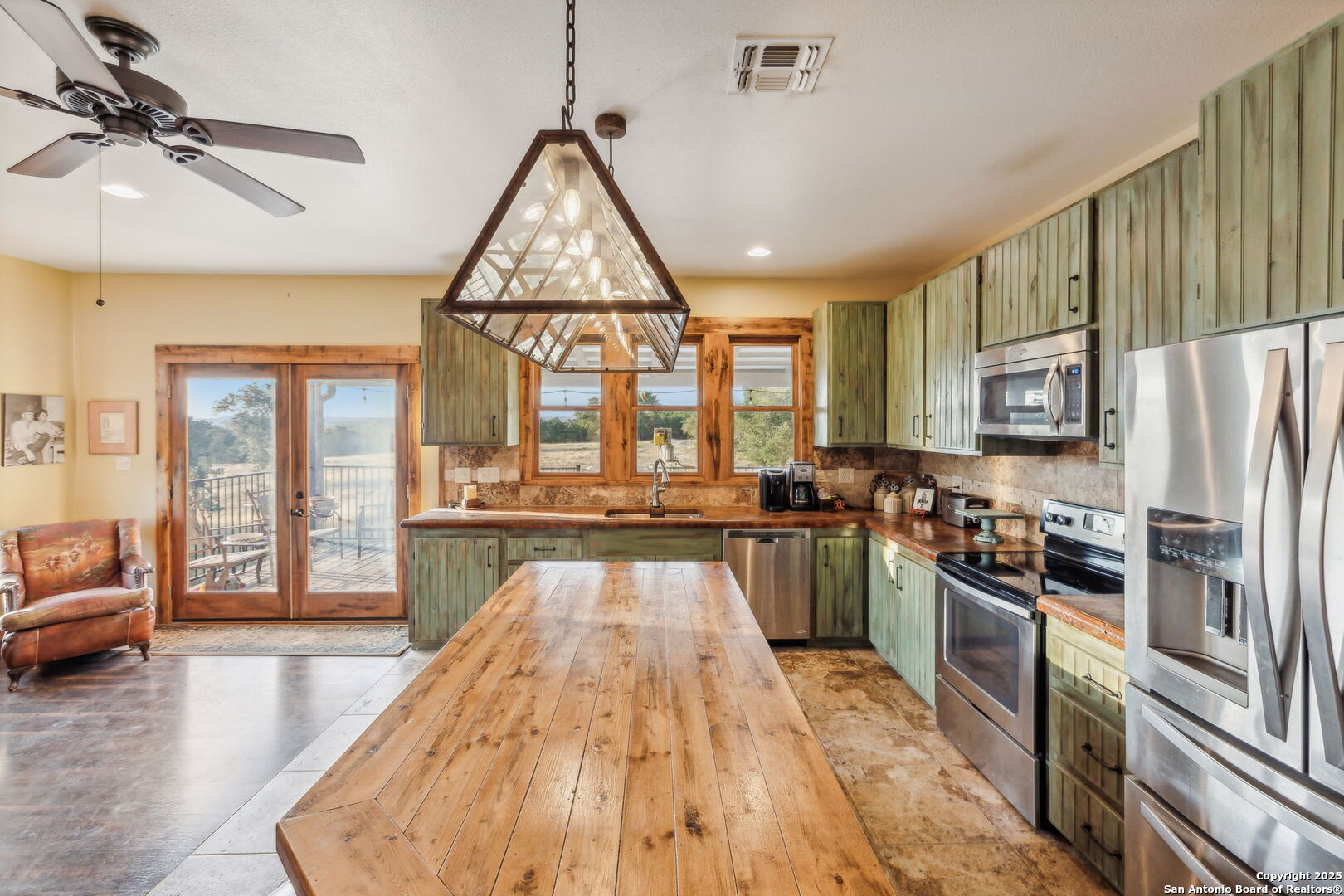232 Stoneleigh Road Center Point, TX 78010 - Photo 12 of 34 a kitchen with stainless steel appliances a refrigerator a stove a sink dishwasher a dining table and chairs with wooden floor