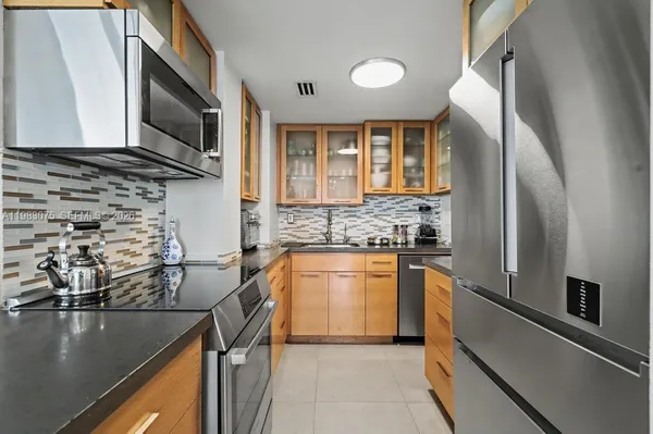 a kitchen with stainless steel appliances granite countertop a refrigerator a stove top oven a sink and dishwasher