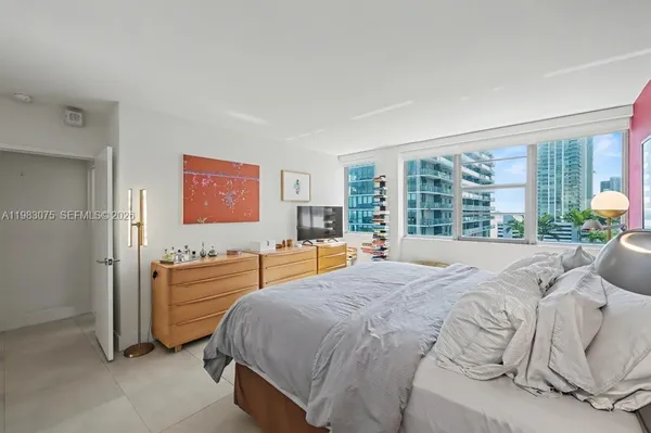 a bedroom with a bed and a large window