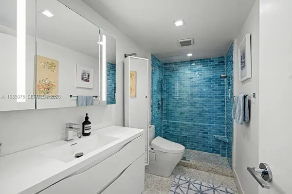 a bathroom with a sink a toilet and shower