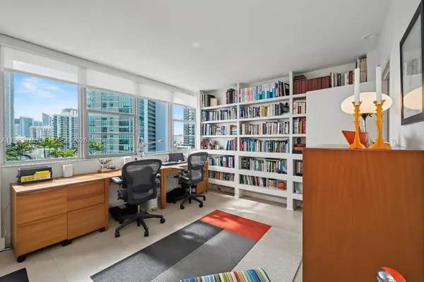 a view of a workspace with furniture and a bookshelf