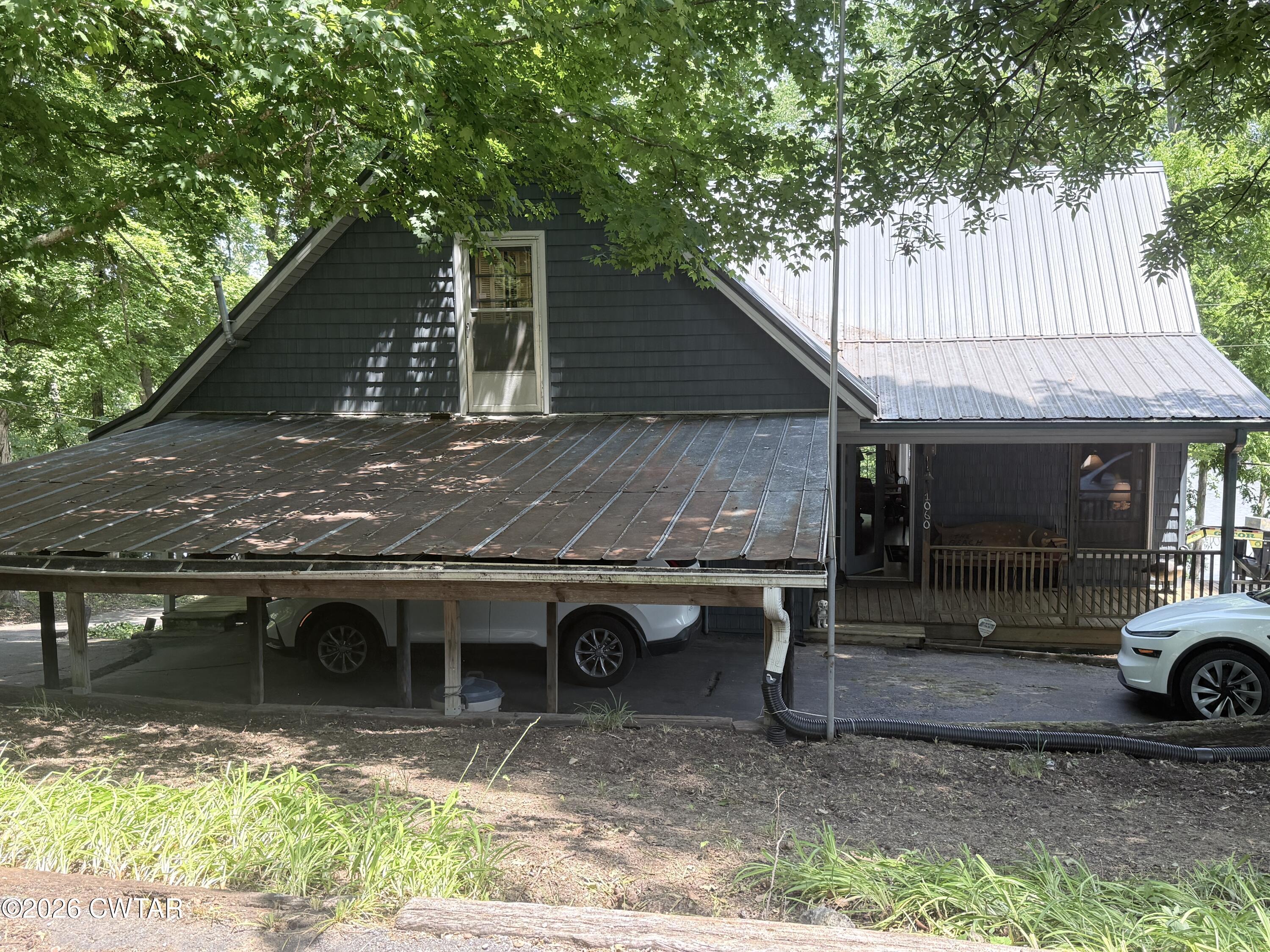 1060 Lost Creek Boat Dock Road Decaturville, TN 38329 - Photo 8 of 40 a backyard of a house with barbeque oven table and chairs