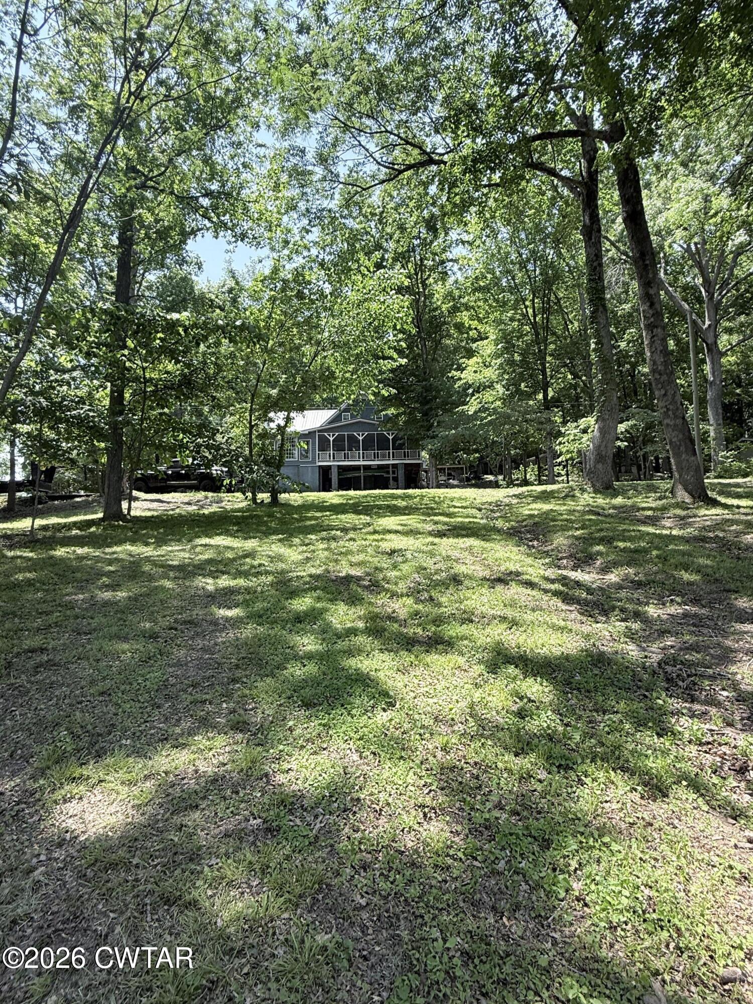 1060 Lost Creek Boat Dock Road Decaturville, TN 38329 - Photo 10 of 40 a big yard with lots of green space and trees in the back
