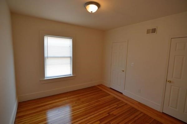 7 Topliff Street, Unit 1 Boston, MA 02122 - Photo 21 of 25 a view of an empty room with wooden floor and a window