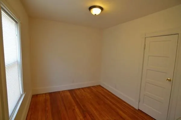 a view of a small space with wooden floor and a window