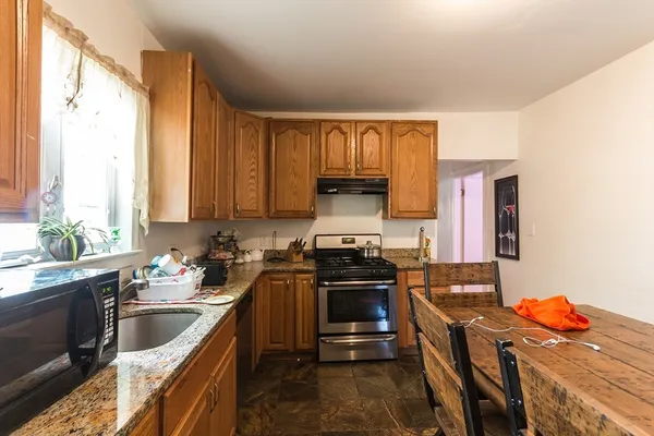 a kitchen with stainless steel appliances a stove a sink a refrigerator and cabinets