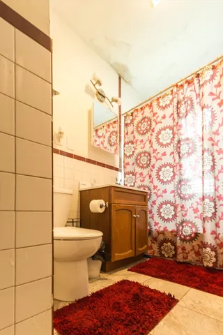 a bathroom with a toilet and a shower curtain