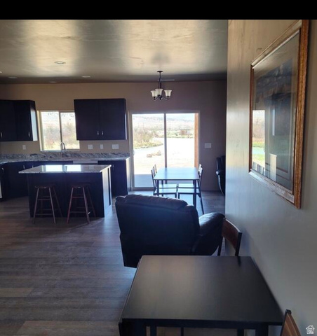 9381 South Sevier Riv Ranch Levan, UT 84639 - Photo 16 of 58 Open-concept living space with wood-finish flooring, dark wood cabinetry, light-toned countertops, and a kitchen island with seating