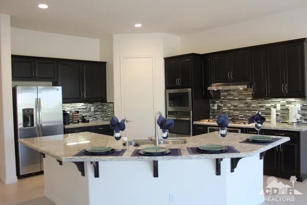 a kitchen with stainless steel appliances a stove top oven a sink and a refrigerator