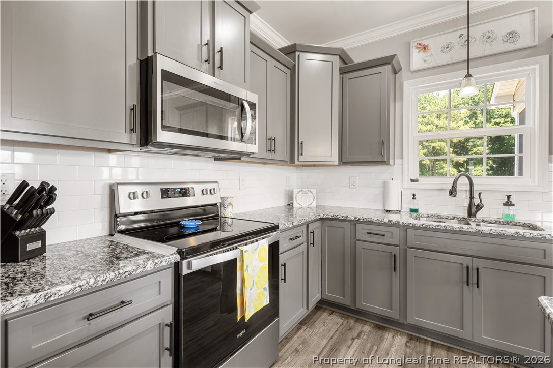 137 Minter School Road Sanford, NC 27332 - Photo 8 of 50 a kitchen with granite countertop a sink cabinets stainless steel appliances and a window
