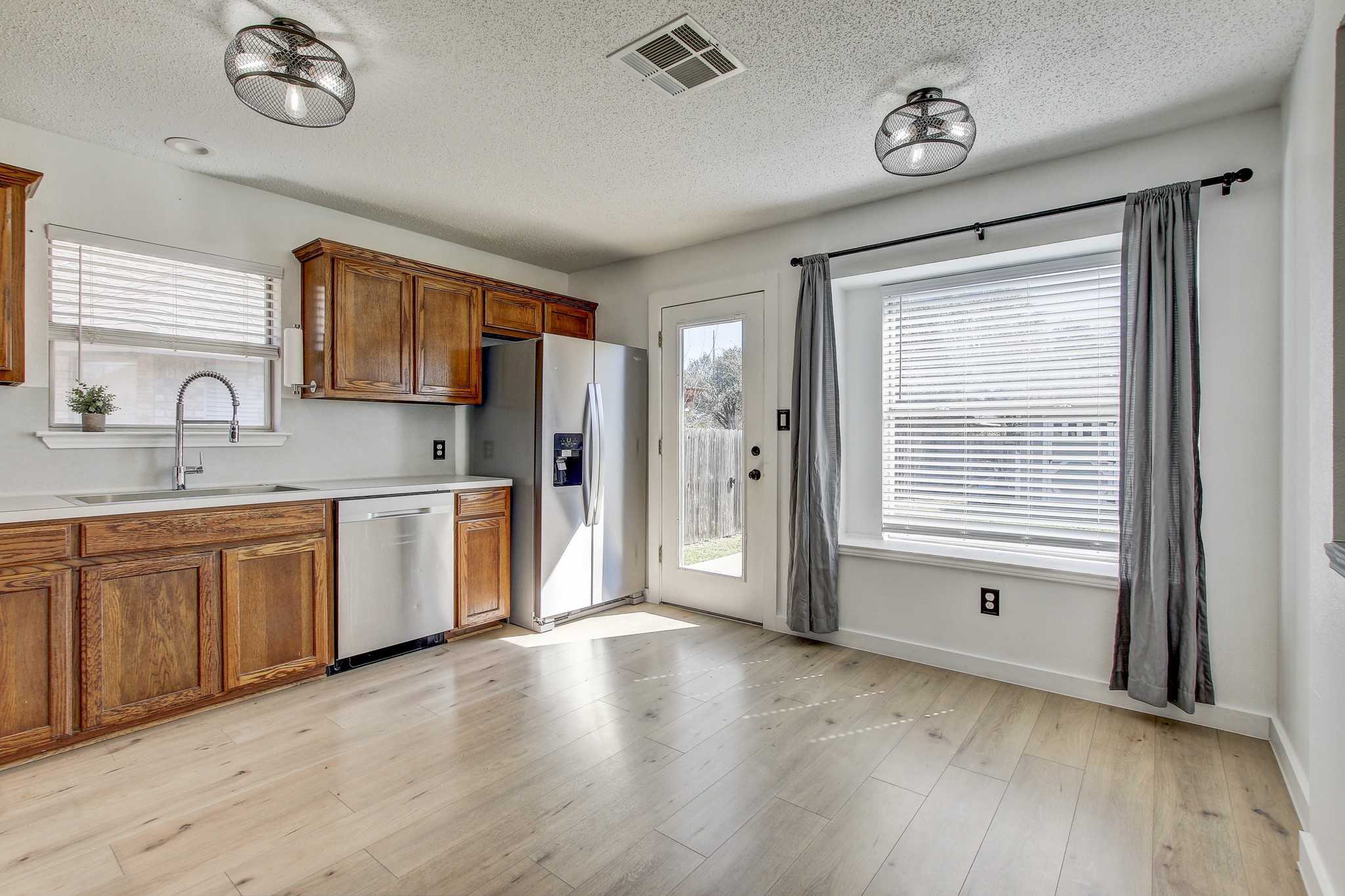 806 Ridge View Drive Leander, TX 78641 - Photo 5 of 30 a open kitchen with stainless steel appliances granite countertop a stove a sink dishwasher and a refrigerator with wooden floor