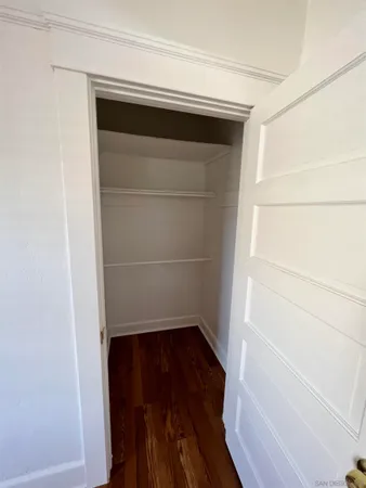a view of walk in closet with wooden floor
