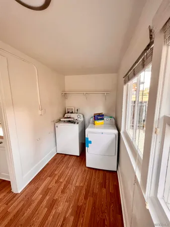 a storage room with wooden floor washer and dryer