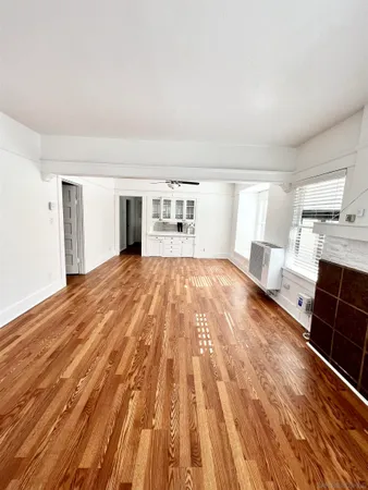 a spacious bedroom with a bed and wooden floor