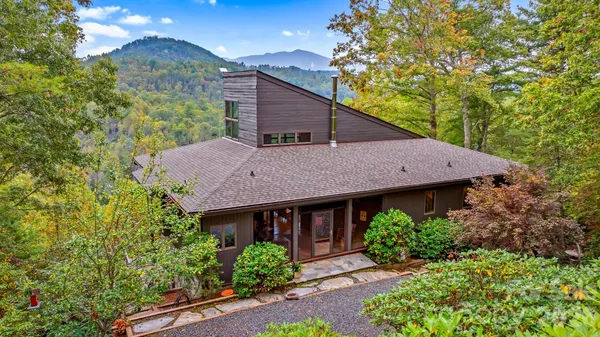 a aerial view of a house with yard and trees