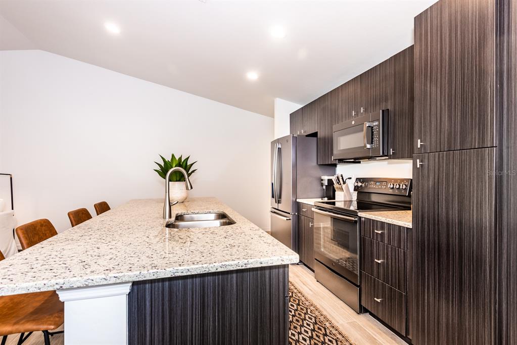 215 Lewis Circle, Unit 111 Punta Gorda, FL 33950 - Photo 12 of 43 a kitchen with stainless steel appliances granite countertop sink stove top oven and refrigerator