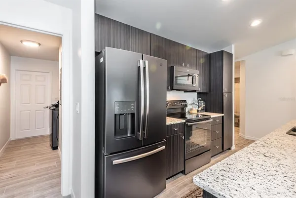 a kitchen with stainless steel appliances granite countertop a refrigerator and a sink