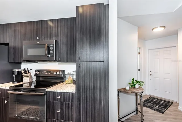 a kitchen with a stove a microwave a sink and cabinets