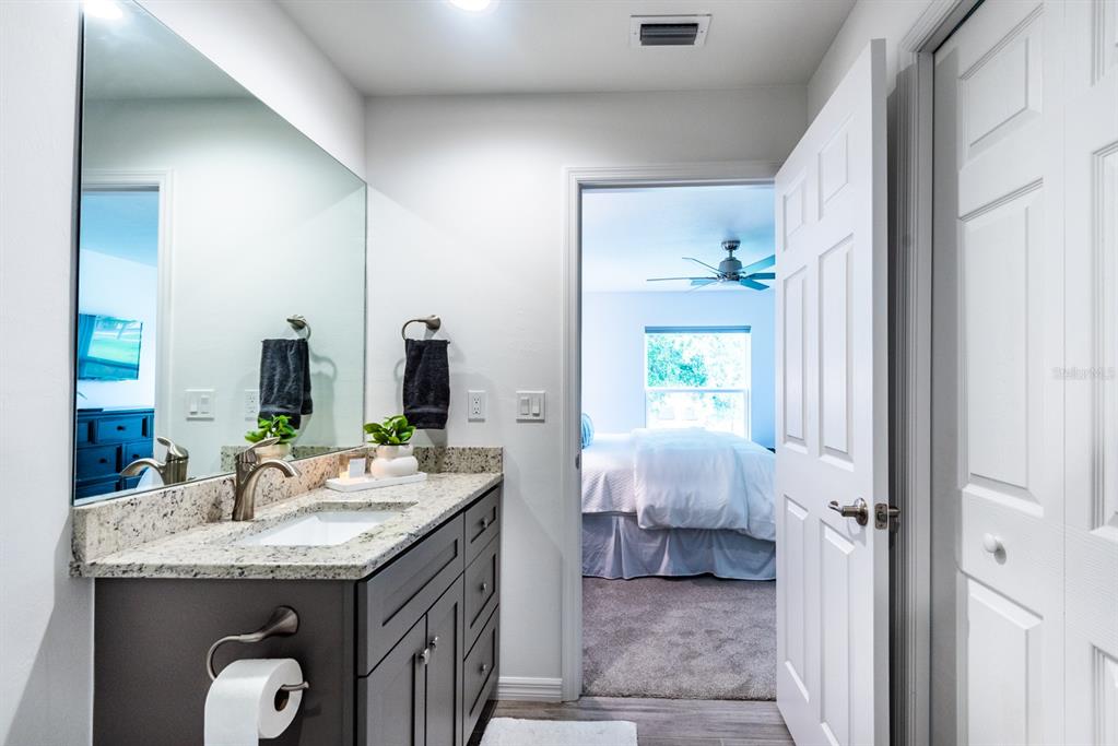 215 Lewis Circle, Unit 111 Punta Gorda, FL 33950 - Photo 37 of 43 a en suite bathroom with a granite countertop sink and a mirror