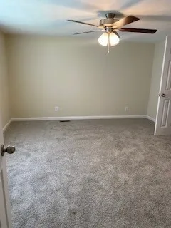 an empty room with a fan and a ceiling fan