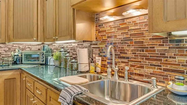 a bathroom with a granite countertop sink and a blue toilet