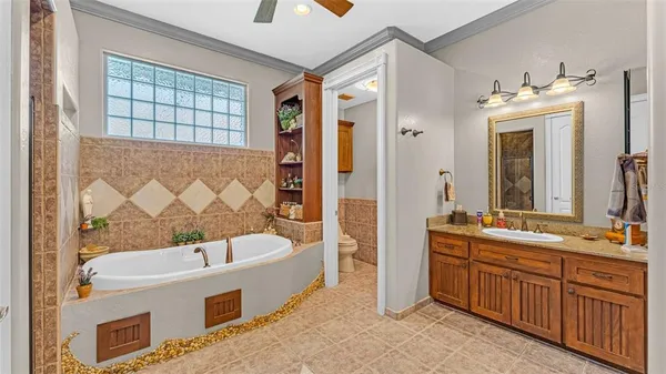 a bathroom with a tub a sink and a large mirror
