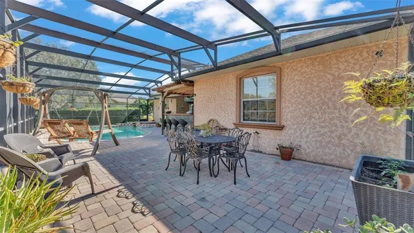 an aerial view of a swimming pool with outdoor seating and yard